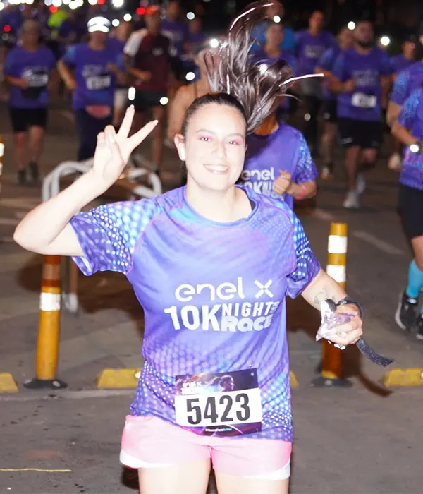 Mujer corriendo de noche en la Enel x night race 10 k